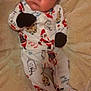 baby, infant, pajamas, mittens, blanket, face, person, cute, holiday, christmas, soft, lying_down, indoors, expression, child, newborn, sleepwear, patterned_clothing, cozy, warm