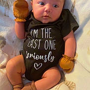 Zane joined the competition — help win amazing prizes! baby, infant, blanket, mittens, onesie, brown_socks, animal_print, curious_expression, lying_down, soft_lighting, chubby_cheeks, cute, cozy, indoor, child, person, clothing, footwear, portrait, newborn