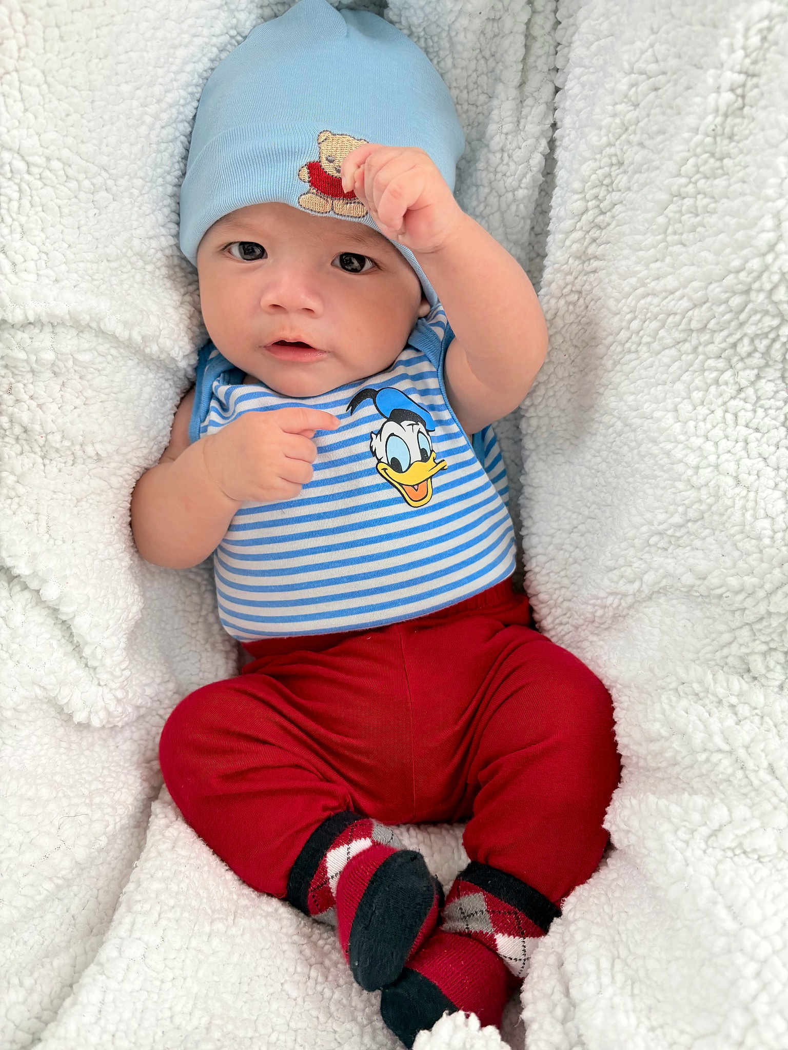 Joab joined the competition — help win amazing prizes! baby, infant, blanket, hat, clothing, striped_shirt, donald_duck, red_pants, socks, cozy, cute, portrait, child, smiling, indoors, soft_texture, warm, casual_wear, cuteness, baby_pose