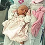 newborn, baby, sleeping, pink_outfit, blanket, mitten, pacifier, hospital_id, infant, cozy, soft_fabric, bed, resting, cute, indoors, toddler, person, child, small, peaceful
