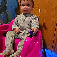 Oaklyn joined the competition — help win amazing prizes! bedroom, blue_light, child, cute, door, eyes, face, floor, hand, indoor, joystick, pajamas, pink_car, portrait, seat, sitting, toddler, toy, wheel, wood_panel