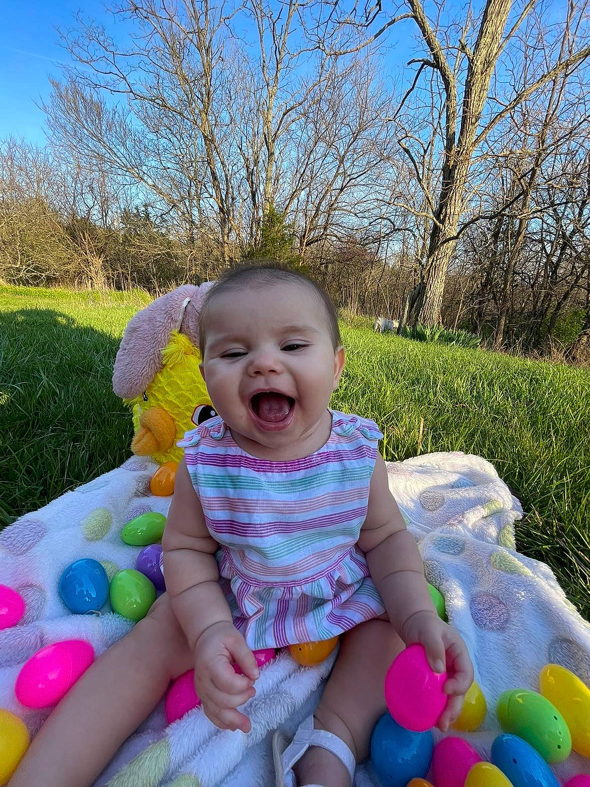 Gabriella joined the competition — help win amazing prizes! baby, baby_toddler_clothing, child, event, facial_expression, fun, grass, happy, leisure, people_in_nature, person, pink, plant, product, recreation, sitting, sky, smile, summer, toddler