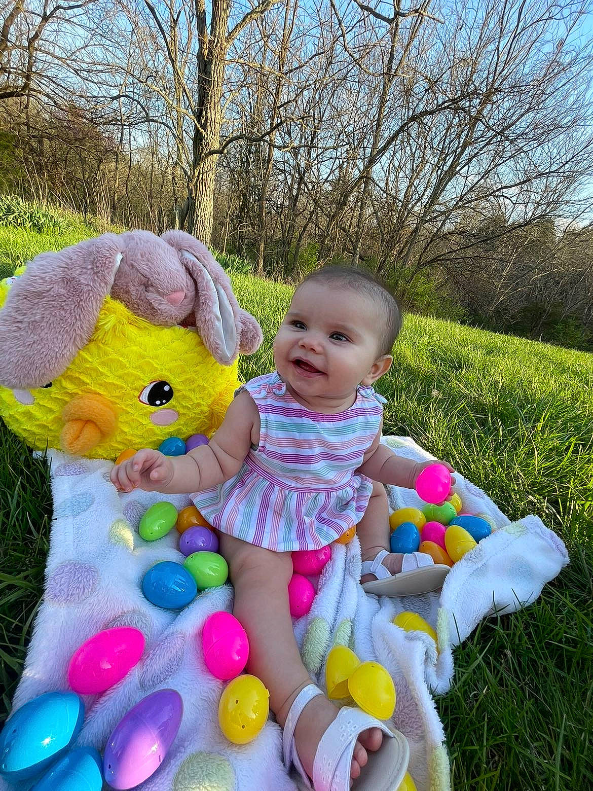 Gabriella is registered to the contest to win money with this photo: baby, baby_toddler_clothing, child, easter, fun, grass, happy, joy, leisure, people_in_nature, person, pink, plant, rabbit, recreation, sitting, sky, stuffed_toy, toddler, toy