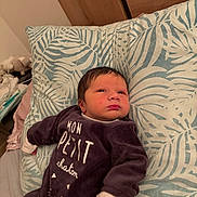 Léonel a rejoint le concours — aidez-le/la à gagner de superbes lots ! baby, infant, onesie, pillow, bed, indoor, face, hand, clothing, sleepwear, person, newborn, cute, expression, portrait, resting, soft, pattern, head, young_child