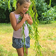 Liah a rejoint le concours — aidez-le/la à gagner de superbes lots ! barefoot, casual_clothing, child, daylight, girl, grass, greenery, happy, leaves, nature, outdoor, playful, portrait, shorts, smiling, summer, tank_top, tree, white_shoes, willow_branch
