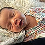 baby, sleeping, blanket, onesie, floral_pattern, infant, peaceful, soft_texture, face, head, skin, mouth, closed_eyes, newborn, resting, comfort, cute, indoors, portrait, child