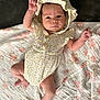 baby, infant, child, romper, bonnet, blanket, floral_pattern, lying_down, cute, adorable, soft_toys, indoor, skin, hand, foot, person, portrait, newborn, clothing, fabric