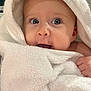 Ava is registered to the contest to win money with this photo: baby, towel, wrapped, face, hand, blue_eyes, skin, cute, infant, portrait, closeup, indoors, soft_texture, newborn, expression, curious, warm, child, head, babyhood