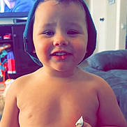 Julionna joined the competition — help win amazing prizes! toddler, child, smiling, shirtless, cap, hair, candy, hand, living_room, television, furniture, couch, person, indoor, young_child, happy, cute, portrait, home, casual