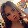 Kylie is registered to the contest to win money with this photo: child, girl, peace_sign, posing, long_hair, orange_dress, sparkle_filter, indoor, kitchen, cabinet, ceiling_fan, lighting, playful, pout, portrait, young, smiling_eyes, casual, home, person