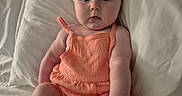 Journee joined the competition — help win amazing prizes! baby, infant, child, romper, peach_clothing, bed, pillow, white_bedding, chubby, sitting, curious, wide_eyes, skin, cute, indoors, portrait, person, soft_light, relaxed, young