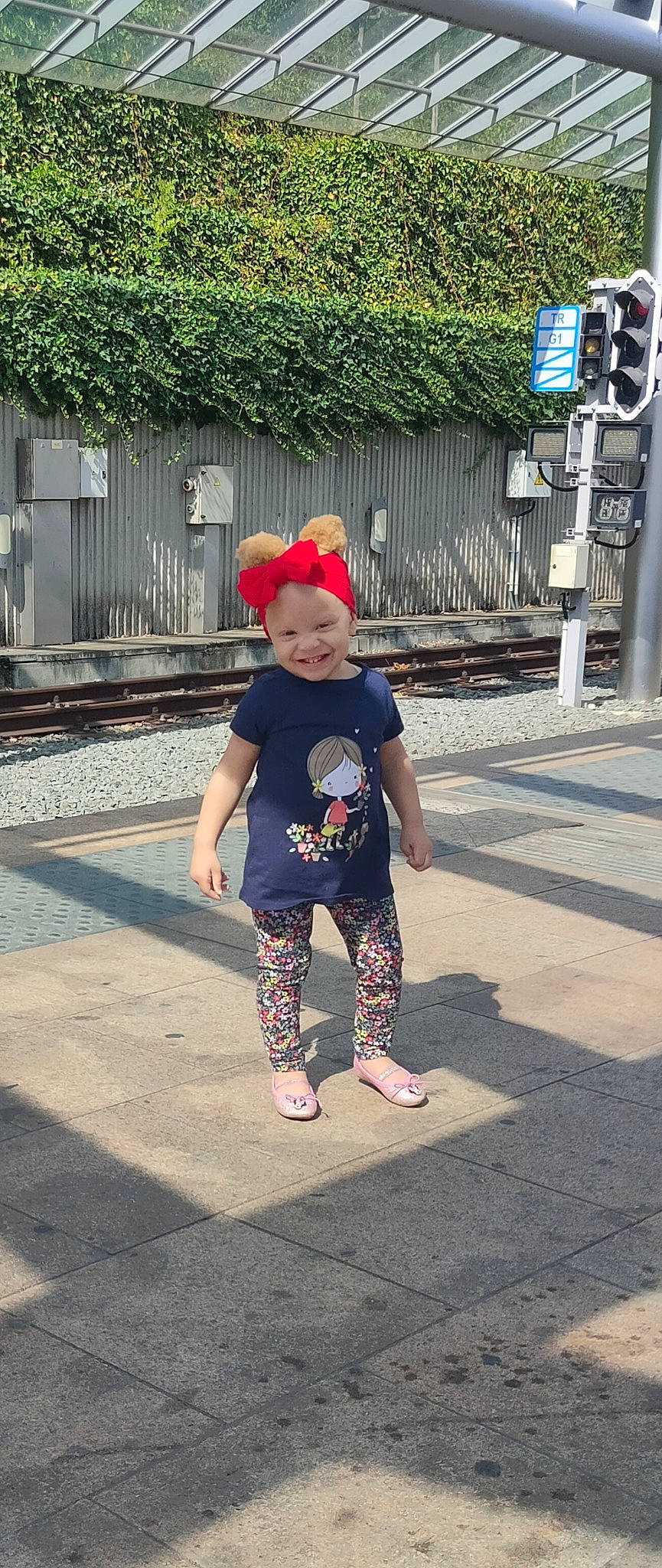 Kayla a rejoint le concours — aidez-le/la à gagner de superbes lots ! asphalt, baby, baby_toddler_clothing, foot, fun, happy, hat, headwear, human_leg, joy, leisure, magenta, person, plant, recreation, road, sandal, sidewalk, smile, street