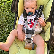 Malachi joined the competition — help win amazing prizes! toddler, child, stroller, pacifier, bottle, grass, sidewalk, outdoor, clothing, baby, seatbelt, yellow_cushion, foot, hand, person, casual, daylight, relaxed, infant, summer