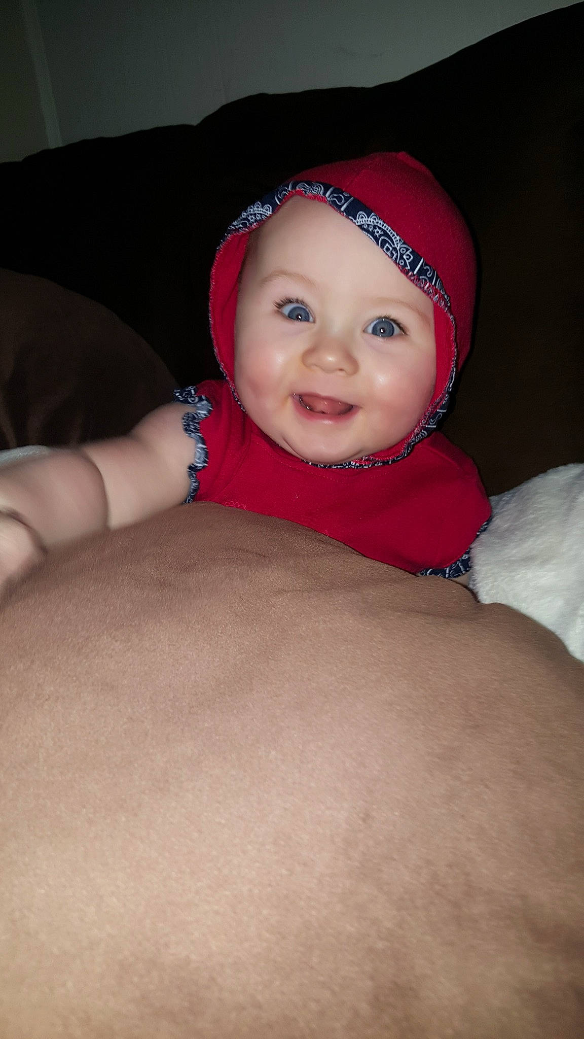 Norah is registered to the contest to win money with this photo: arm, baby, baby_toddler_clothing, cheek, chest, comfort, eye, eyebrow, face, flash_photography, happy, head, headgear, headwear, human_body, leg, lip, nose, person, sleeve