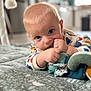 baby, infant, child, blue_eyes, plush_toy, blanket, indoors, home, soft_toy, curious, crawling, patterned_blanket, baby_clothing, close_up, cute, floor, head, hands, chewing, person