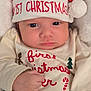 Aaron is registered to the contest to win money with this photo: baby, infant, child, christmas, holiday, santa_hat, clothing, cute, face, portrait, festive, red, white, green, blanket, button, hand, smile, indoors, cozy