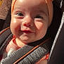 baby, infant, headband, bow, car_seat, sunlight, close_up, face, cute, child, smile, straps, clothing, seatbelt, young_child, indoors, safety, skin, expression, portrait