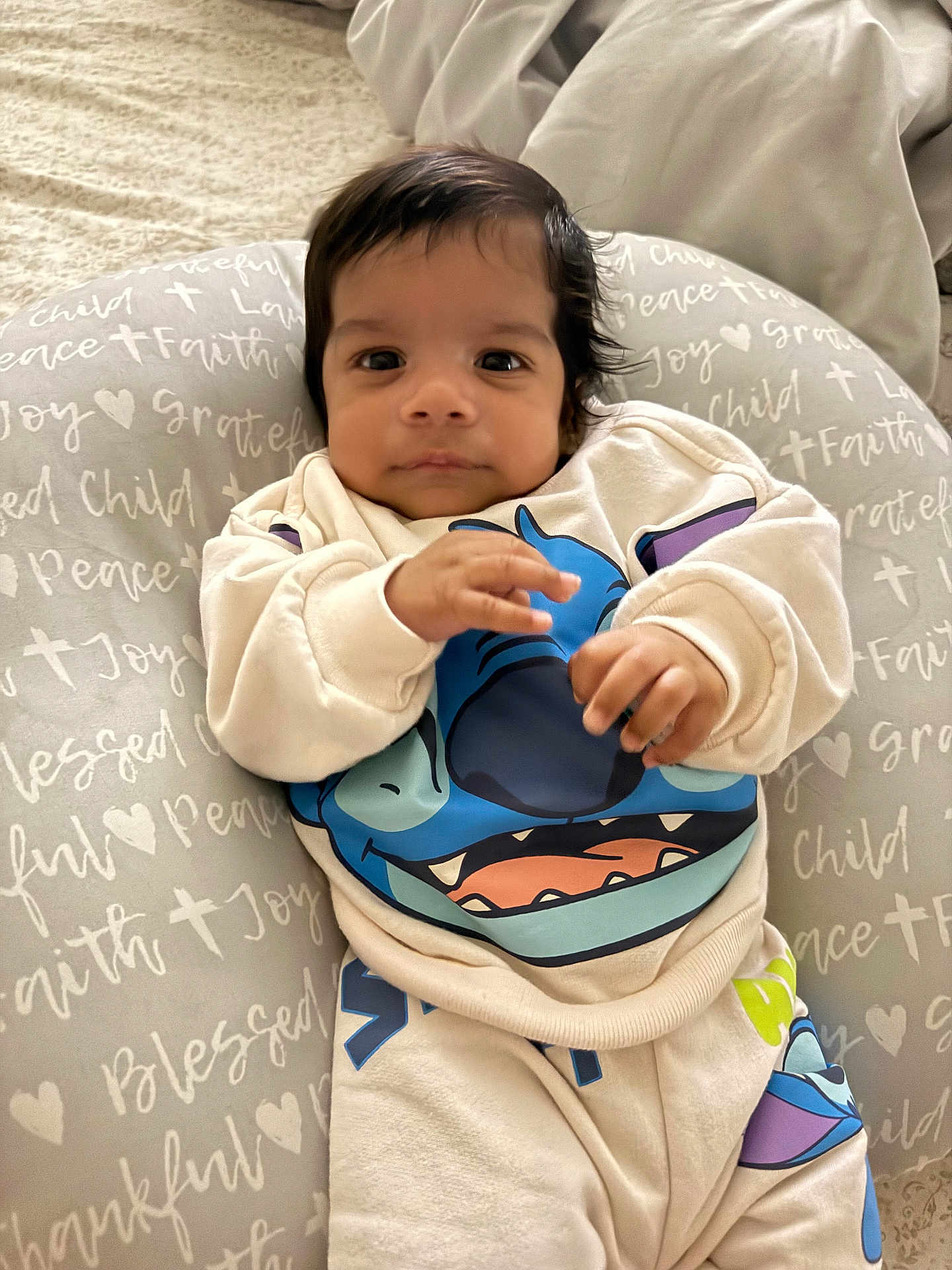 Ian Montiel joined the competition — help win amazing prizes! baby, infant, child, cute, face, clothing, sweatshirt, pants, cushion, text, pattern, indoor, portrait, looking, hands, soft, comfortable, young, smiling, cozy