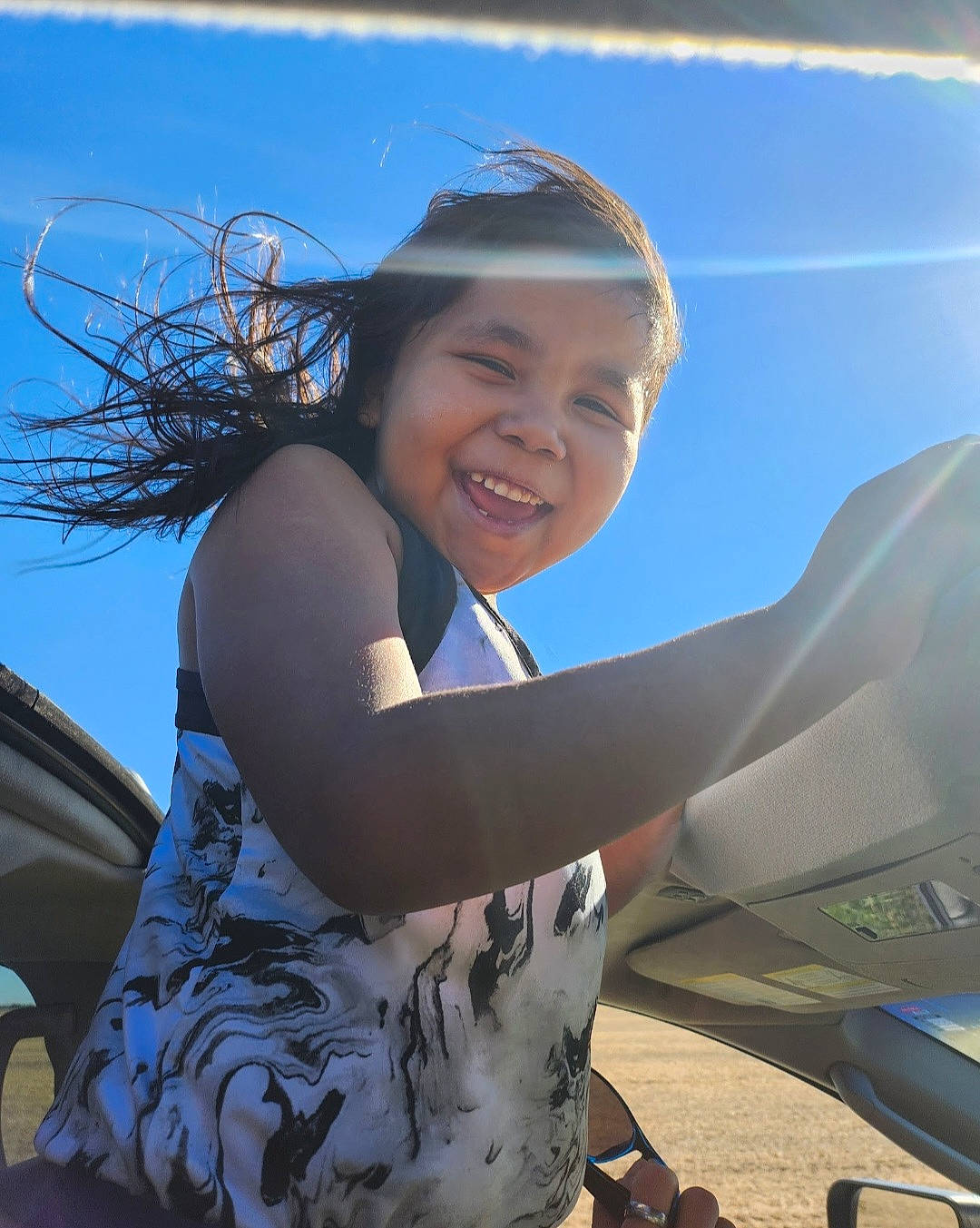 Zi Zi is registered to the contest to win money with this photo: automotive_exterior, automotive_wheel_system, azure, bumper, cool, electric_blue, flash_photography, fun, happy, joy, landscape, leisure, motor_vehicle, person, personal_luxury_car, recreation, sky, smile, toddler, travel