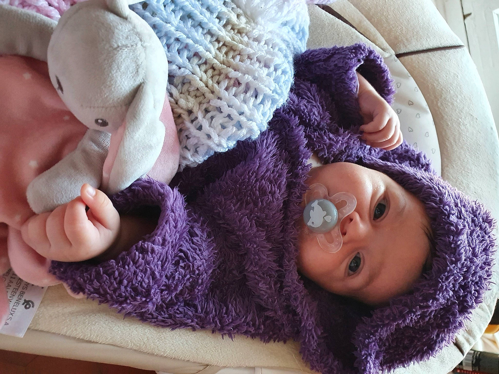 Kessy participe au concours pour gagner de l'argent avec cette photo : baby, baby_toddler_clothing, cheek, child, comfort, craft, creative_arts, fur, headgear, headwear, human_body, joint, knit_cap, pattern, person, purple, sleeve, textile, toddler, violet