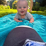 Adrien is registered to the contest to win money with this photo: baby, towel, grass, outdoor, smile, person, barefoot, sunlight, blue, happy, infant, face, child, nature, daylight, casual, greenery, playful, summer, relaxation