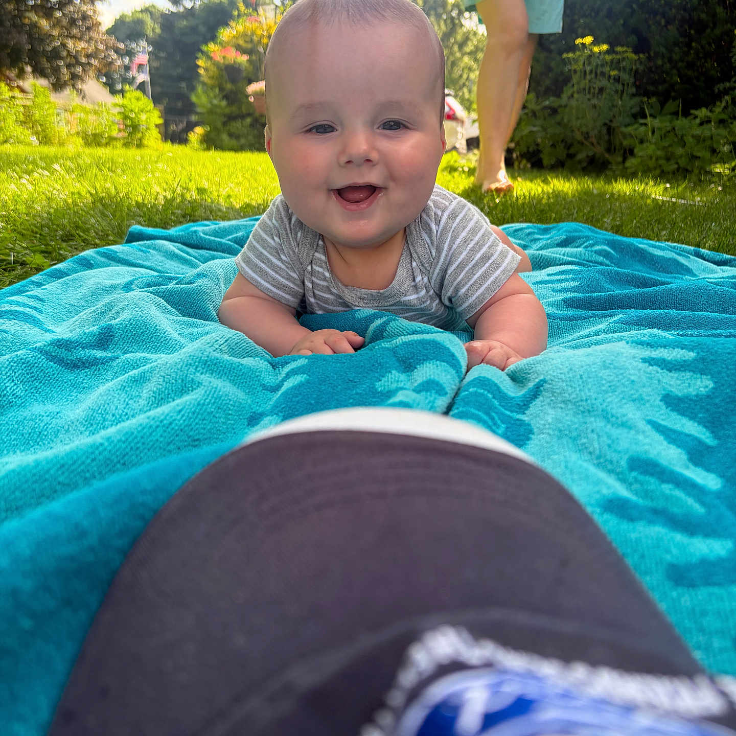 Adrien is registered to the contest to win money with this photo: baby, towel, grass, outdoor, smile, person, barefoot, sunlight, blue, happy, infant, face, child, nature, daylight, casual, greenery, playful, summer, relaxation