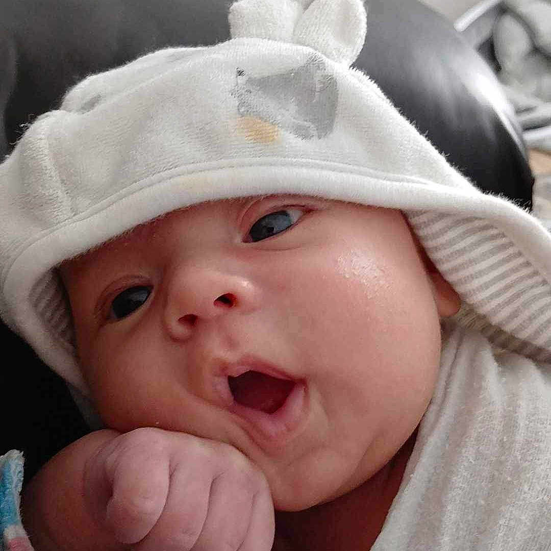 Jacob joined the competition — help win amazing prizes! baby, babylaughing, bonnet, cap, clothing, face, happy, hat, head, hood, hoodie, knitwear, newborn, person, photography, portrait, smile, sweater, sweatshirt, towel