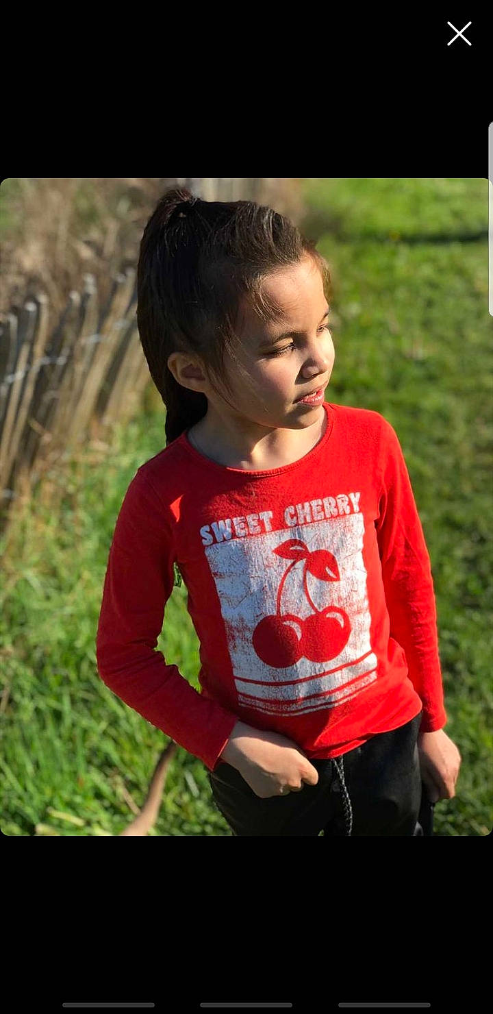 Naomi a rejoint le concours — aidez-le/la à gagner de superbes lots ! baby_toddler_clothing, brown_hair, child, chin, face, flash_photography, fun, grass, grassland, happy, leisure, pattern, people_in_nature, person, plant, recreation, sitting, sleeve, t_shirt, toddler