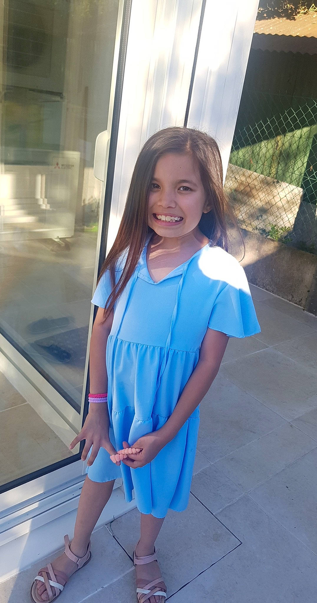 Naomi participe au concours pour gagner de l'argent avec cette photo : brown_hair, child, dress, electric_blue, fun, happy, human_leg, jewellery, joy, knee, leisure, long_hair, person, skin, sleeve, smile, thigh, toddler, travel, trunk