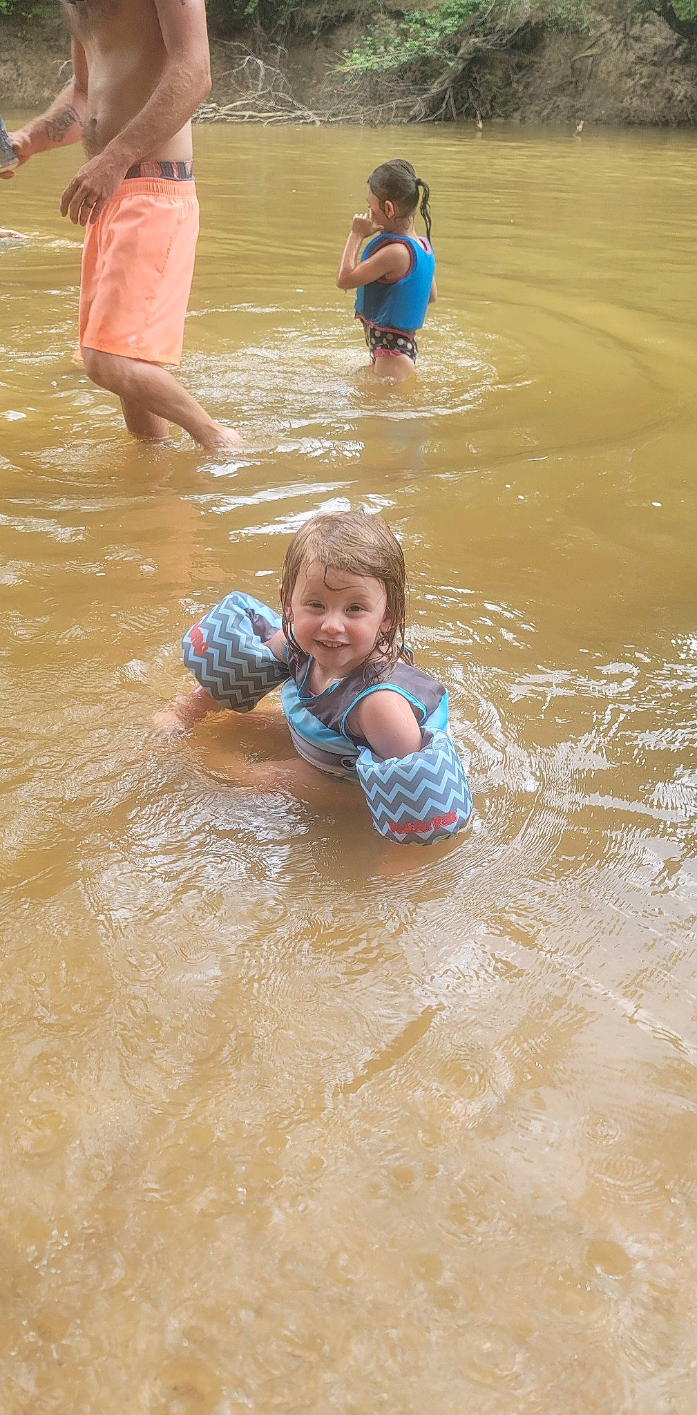 Bayleigh is registered to the contest to win money with this photo: bathing, body_of_water, child, event, face, fun, happy, joy, lake, leisure, person, personal_protective_equipment, play, recreation, smile, summer, t_shirt, toddler, vacation, water