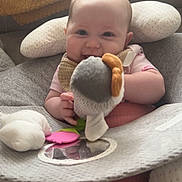 Ivy joined the competition — help win amazing prizes! baby, child, smiling, plush_toy, cushion, seated, infant, pink_clothing, bib, mirror, soft_toys, indoors, cute, happy, person, young_child, comfort, head_support, playful, closeup