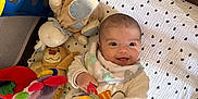 Marylia participe au concours pour gagner de l'argent avec cette photo : baby, blanket, child, clothing, colorful, cushion, fabric, face, happy, head, indoor, infant, person, playpen, playtime, plush_toy, smile, soft, stuffed_animal, toy