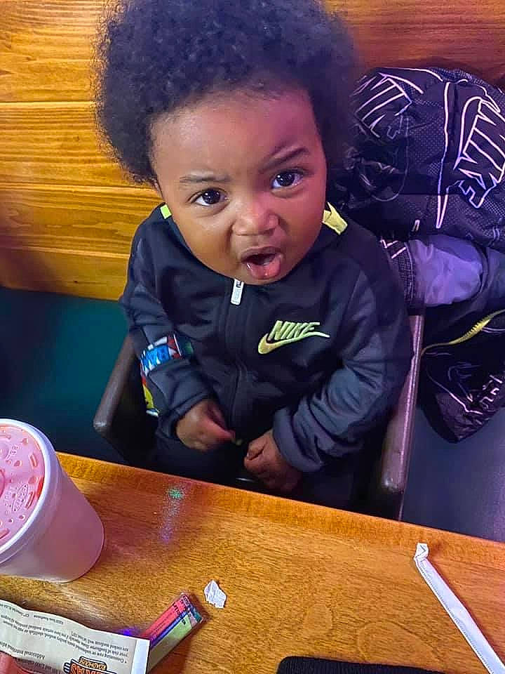 Maurice is registered to the contest to win money with this photo: afro, beauty, chair, cheek, child, eyelash, face, fun, happy, head, ingredient, jacket, nose, outerwear, person, play, sitting, square, surprise, t_shirt