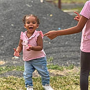 Naëlys participe au concours pour gagner de l'argent avec cette photo : toddler, child, outdoor, grass, pink_shirt, jeans, white_shoes, smiling, laughing, person, playful, pointing_hand, young_child, happy, nature, daylight, casual_clothing, sibling, fun, blurred_background