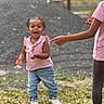 toddler, child, outdoor, grass, pink_shirt, jeans, white_shoes, smiling, laughing, person, playful, pointing_hand, young_child, happy, nature, daylight, casual_clothing, sibling, fun, blurred_background