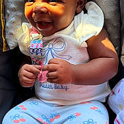 Naioir joined the competition — help win amazing prizes! baby, smiling, headband, bow, cushion, seat, clothing, pants, pattern, cherry, sunlight, happy, child, infant, cute, portrait, sitting, person, indoors, warm