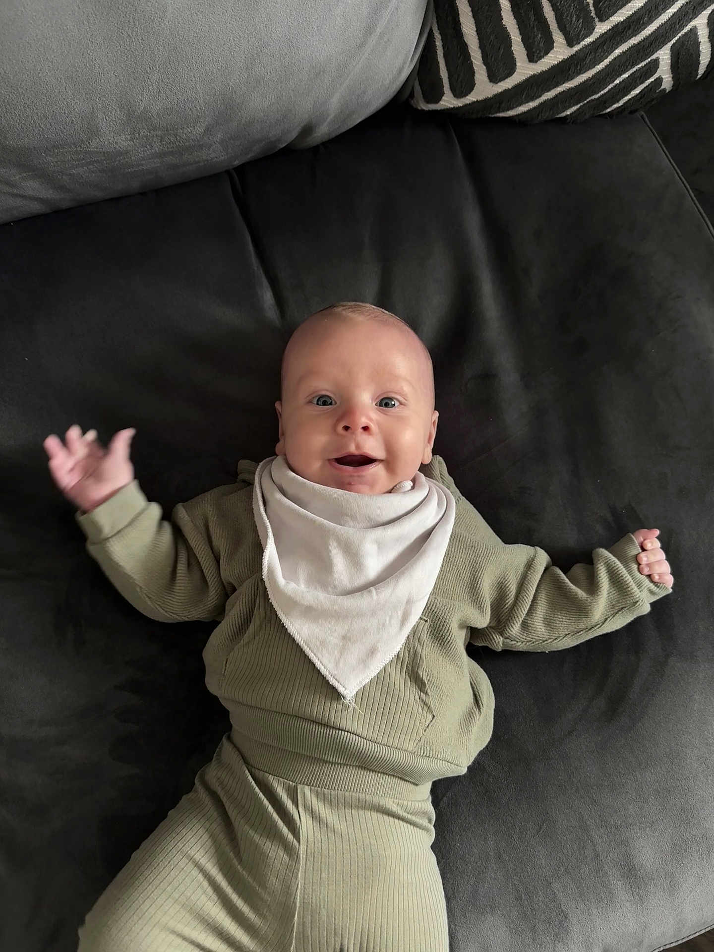 Chester joined the competition — help win amazing prizes! baby, infant, smiling, face, clothing, bib, couch, pillow, fabric, happy, person, indoor, cute, child, sitting, expression, portrait, soft, texture, relaxation