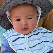 Louis joined the competition — help win amazing prizes! baby, child, hat, wide_brimmed_hat, animal_print, bib, striped_bib, blue_clothing, face, headwear, outdoor, person, cute, chubby_cheeks, portrait, infant, young_child, soft_light, curious_expression, closeup
