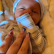 Elias joined the competition — help win amazing prizes! baby, infant, hand, nails, blue_nails, blanket, striped_clothing, hat, soft_texture, cozy, sleepy, closeup, skin, cute, comfort, newborn, person, resting, indoor, warm
