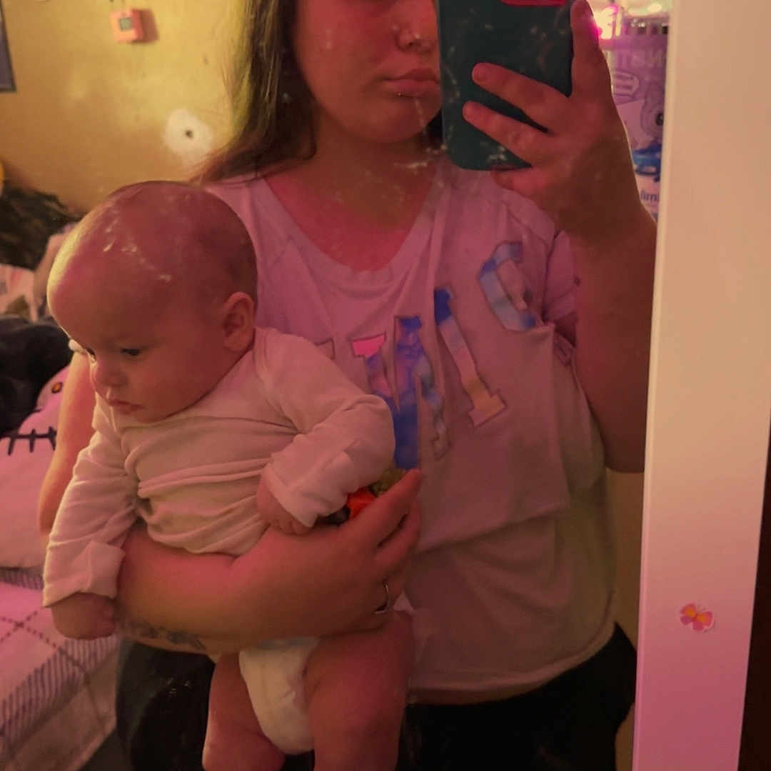 Elias joined the competition — help win amazing prizes! baby, person, mirror, selfie, indoor, bed, furniture, phone, clothing, holding, shorts, long_hair, wall, shelf, bottle, room, reflection, face, head, skin