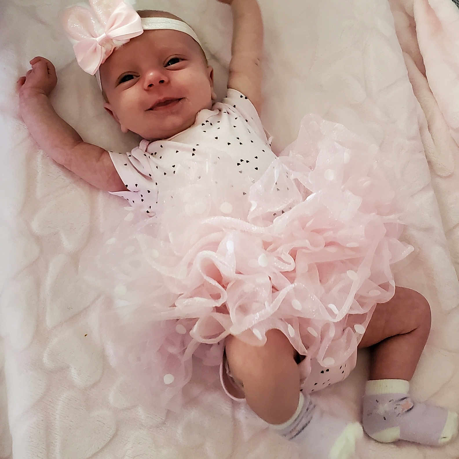 Olivia is registered to the contest to win money with this photo: baby, bed, bodypart, bonnet, clothing, crib, dress, face, finger, furniture, hand, hat, head, hosiery, infantbed, newborn, person, photography, portrait, sock