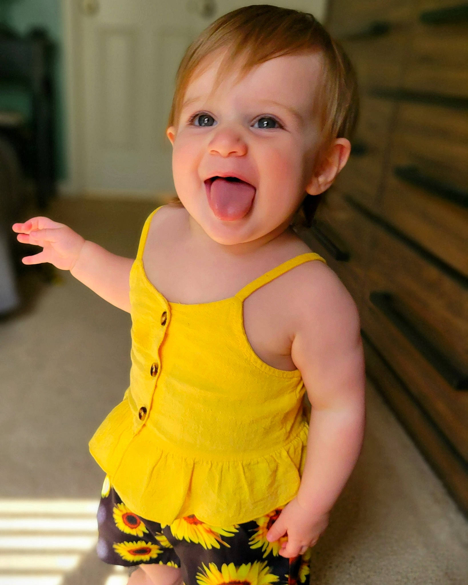 Elsie is registered to the contest to win money with this photo: active_tank, baby, baby_toddler_clothing, cheek, eye, finger, gesture, hand, happy, iris, neck, nose, person, shoulder, skin, sleeve, sleeveless_shirt, smile, standing, thumb