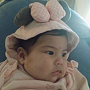 Aylany González is registered to the contest to win money with this photo: baby, infant, child, hood, polka_dot, pink_clothing, face, cheek, eyes, hand, sweater, soft_toy, couch, indoor, close_up, portrait, calm, fabric, curtain, looking_right