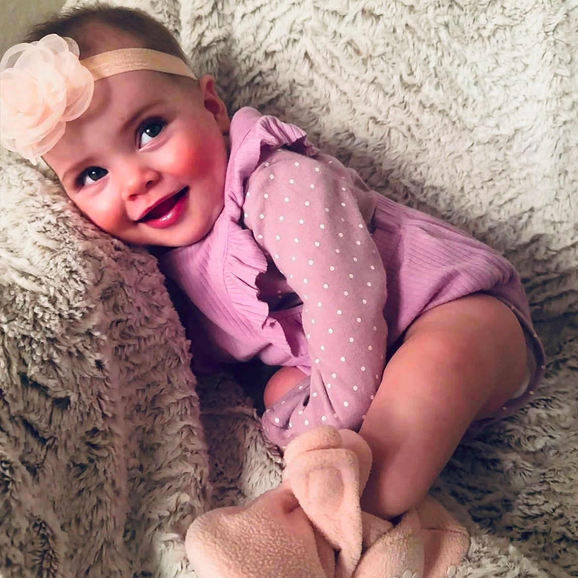 Mi Amor is registered to the contest to win money with this photo: baby, blanket, booties, cheeks, child, cozy, cute, face, flower, happy, headband, indoors, infant, polka_dots, portrait, purple_clothing, sitting, skin, smile, soft_texture