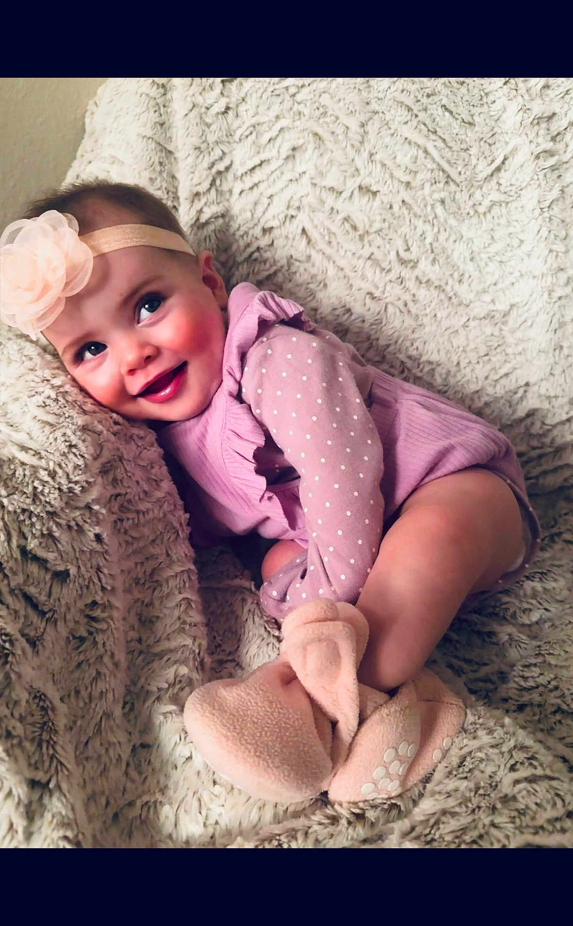 Mi Amor is registered to the contest to win money with this photo: baby, child, infant, smile, headband, flower, purple_clothing, polka_dots, blanket, soft_texture, booties, cute, happy, cozy, indoors, portrait, sitting, face, skin, cheeks