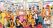 Mehareen is registered to the contest to win money with this photo: adults, beard, carpet, celebration, children, community, culture, diverse_ages, group, headwear, indoor, orange_scarf, people, portrait, posing, religious_gathering, sikh, smiling, traditional_clothing, turban