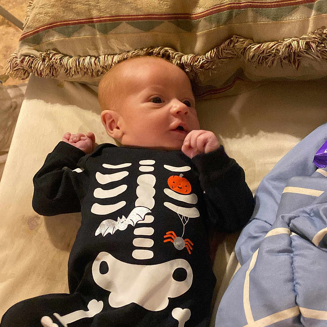 Liam is registered to the contest to win money with this photo: baby, bed, blanket, bodypart, clothing, couch, crib, cushion, face, finger, furniture, hand, head, homedecor, infantbed, newborn, pants, person, photography, portrait