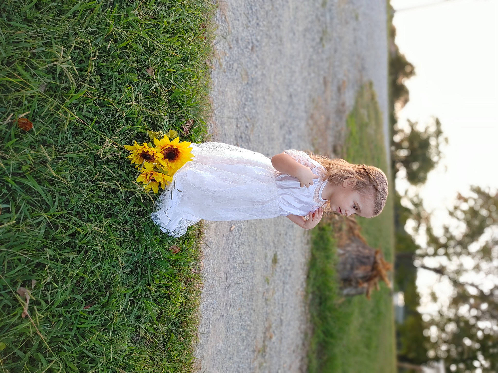 Lexi is registered to the contest to win money with this photo: ceremony, child, dress, floral_design, flower, fun, grass, grass_family, hand, happy, landscape, leaf, leisure, people_in_nature, person, petal, plant, sky, toddler, tree