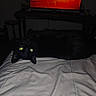 Felix is registered to the contest to win money with this photo: animal, bed, black_cat, blanket, cat, cozy, curious, dark, dim_light, furniture, home, indoor, living_room, night, pet, relaxed, resting, television, upside_down, yellow_eyes
