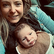 Maël a rejoint le concours — aidez-le/la à gagner de superbes lots ! woman, baby, smile, face, person, infant, clothing, bib, denim_jacket, scarf, car_interior, window, hair, skin, eyes, nose_piercing, sitting, portrait, closeup, warmth